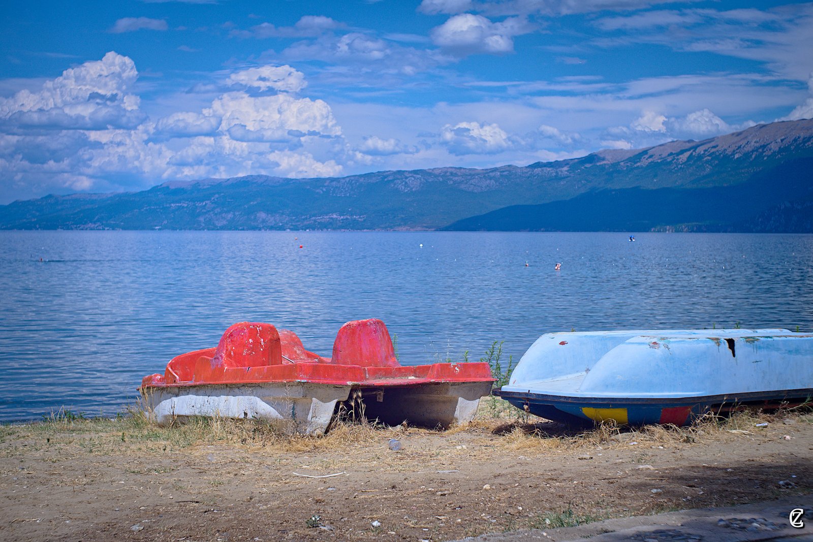 Weathered old fishing boats lined up along the Pogradec shore, their hulls worn by decades on the lake